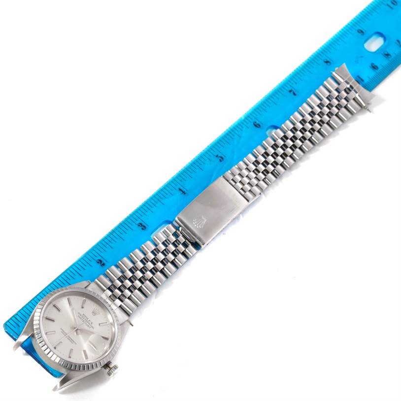 This image shows the Rolex Datejust 16220 Men's Stainless Steel Silver Dial 16220 Men's Stainless Steel Silver Dial watch placed next to a ruler, highlighting its face, bracelet, clasp, and part of its crown.