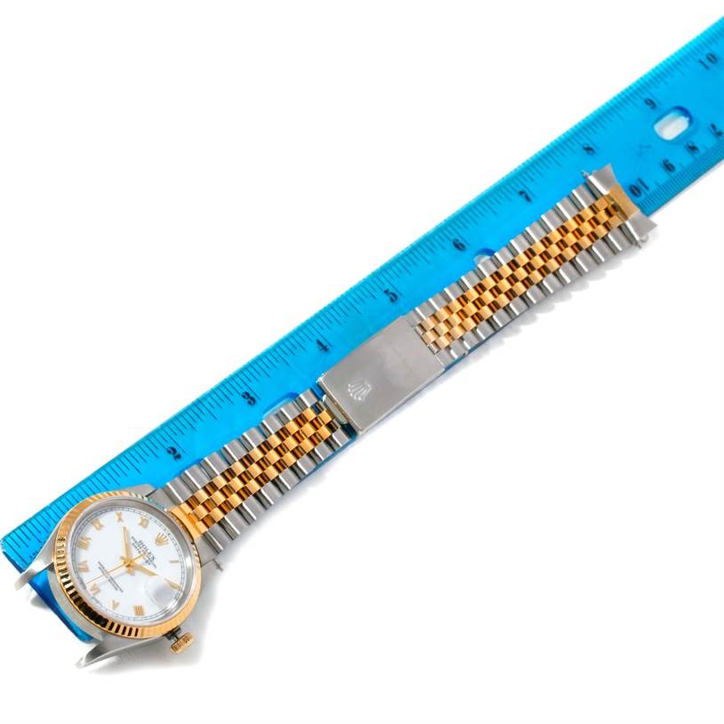 The image shows a Rolex Datejust 16233 Men's Steel and Gold (two tone) White Dial 16233 Men's Steel and Gold (two tone) White Dial watch laid flat, with focus on the face, Jubilee bracelet, and clasp, beside a blue ruler for scale.