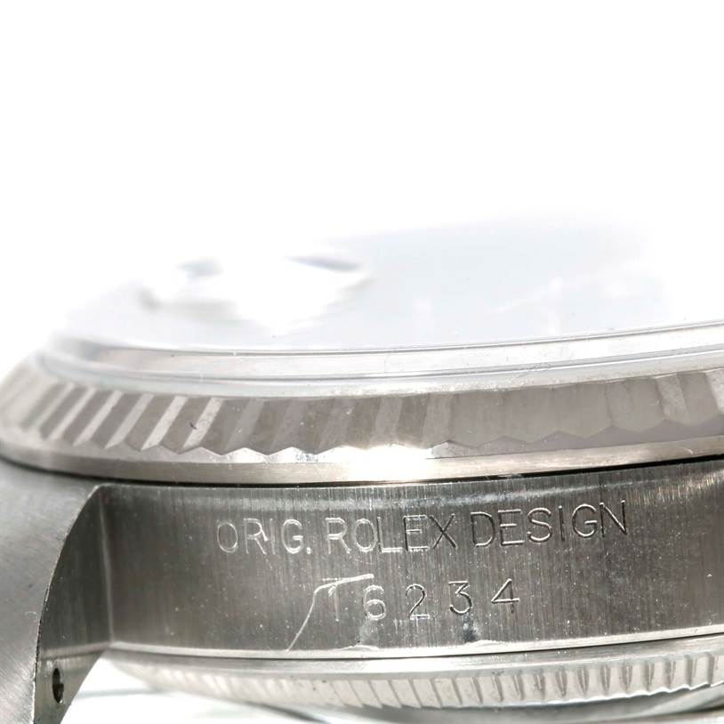This image shows a close-up side view of the Rolex Datejust 16234 Men's Stainless Steel Silver Dial 16234 Men's Stainless Steel Silver Dial case, highlighting the serial number and "Orig. Rolex Design" engraving.
