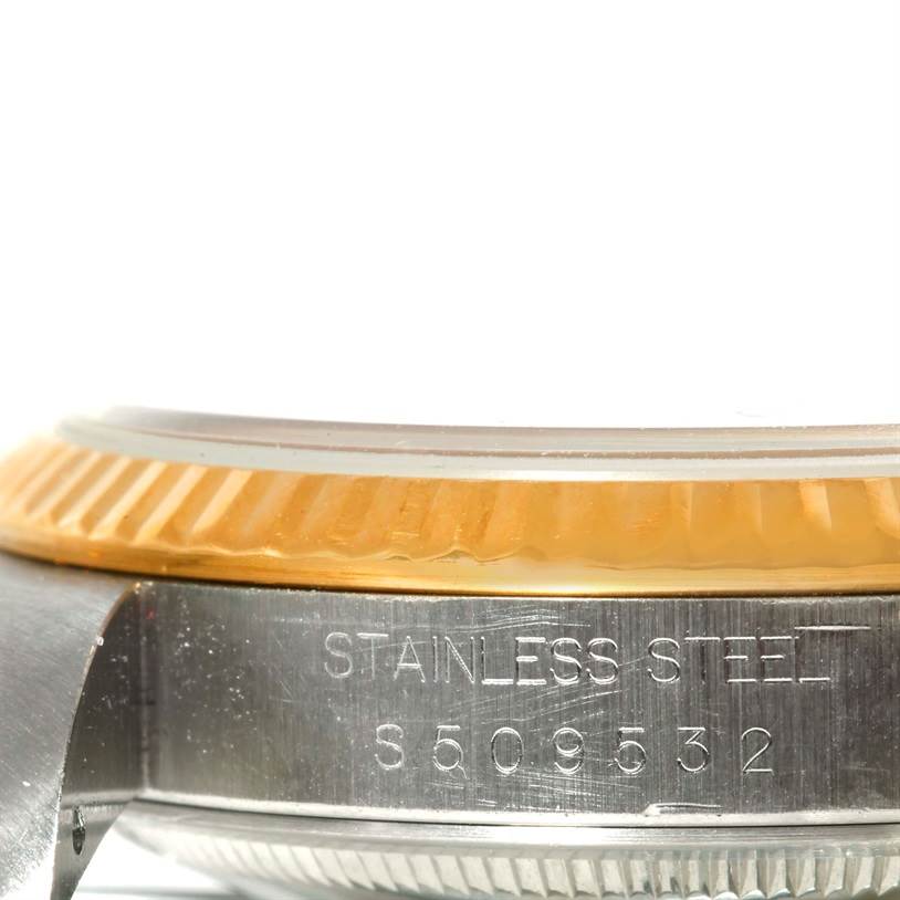This close-up image shows the stainless steel case and serial number of the Rolex Datejust 16233 Men's Steel and Gold (two tone) Champagne Dial 16233 Men's Steel and Gold (two tone) Champagne Dial model, including part of the bezel.