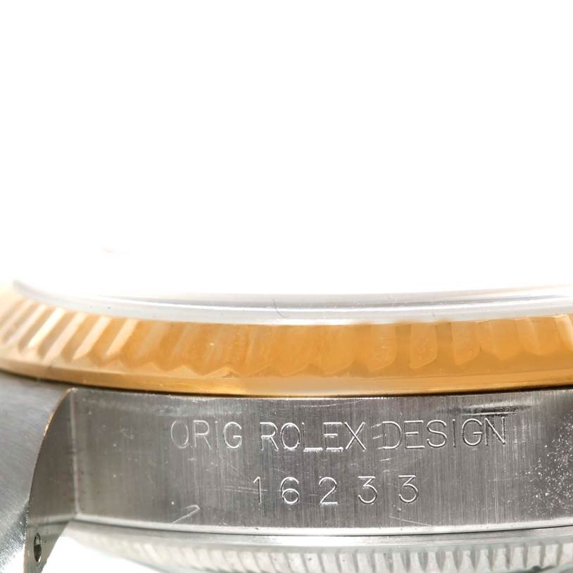The image shows a close-up side view of the Rolex Datejust 16233 Men's Steel and Gold (two tone) Champagne Dial 16233 Men's Steel and Gold (two tone) Champagne Dial watch case, including part of its bezel and engraved model number.