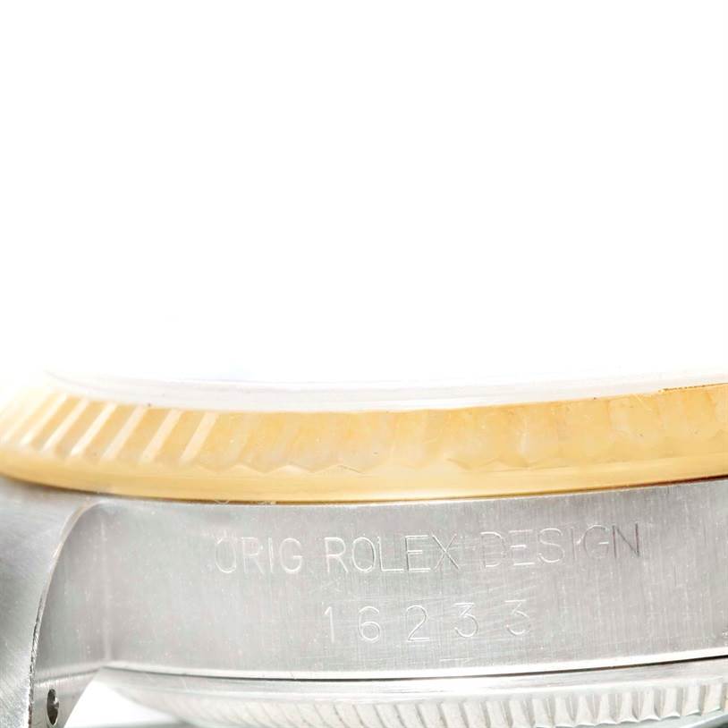 The image shows a close-up side view of the Rolex Datejust 16233 Men's Steel and Gold (two tone) Champagne Dial 16233 Men's Steel and Gold (two tone) Champagne Dial model, highlighting the fluted bezel and the engraved case side.