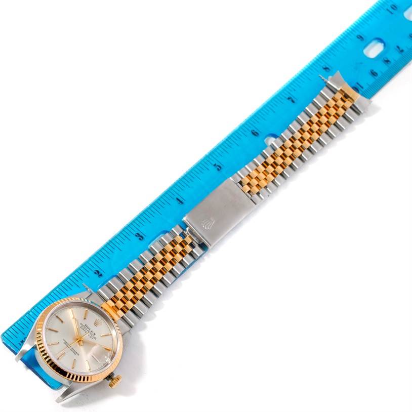 The image shows a Rolex Datejust 16233 Men's Steel and Gold (two tone) Silver Dial 16233 Men's Steel and Gold (two tone) Silver Dial watch laid flat next to a blue ruler, displaying its face, bezel, and bracelet.