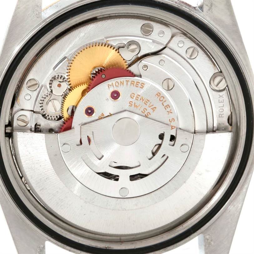 The image shows the inner mechanical parts of a Rolex Datejust 16233 Men's Steel and Gold (two tone) Champagne Dial 16233 Men's Steel and Gold (two tone) Champagne Dial watch from a back perspective, highlighting gears and the movement mechanism.