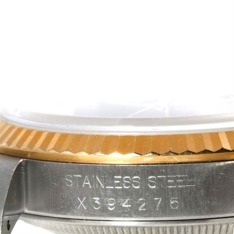 The image shows a close-up of the side view of a Rolex Datejust 16233 Men's Steel and Gold (two tone) Black Dial 16233 Men's Steel and Gold (two tone) Black Dial, highlighting the bezel and serial number engraving.