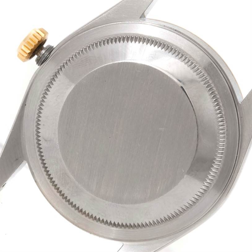 The image shows the back case and crown of a Rolex Datejust 16233 Men's Steel and Gold (two tone) Black Dial 16233 Men's Steel and Gold (two tone) Black Dial watch from a top-down angle.