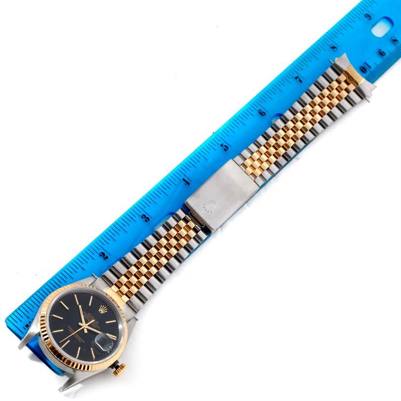 The image shows a Rolex Datejust 16233 Men's Steel and Gold (two tone) Black Dial 16233 Men's Steel and Gold (two tone) Black Dial watch face and Jubilee bracelet measured next to a ruler.