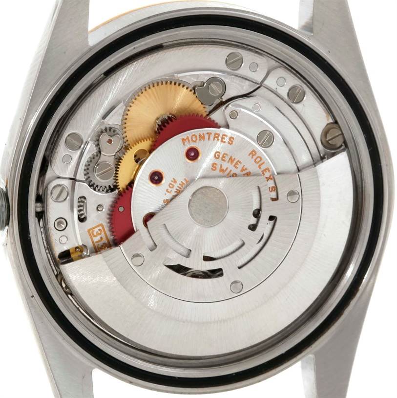 The image shows the intricate inner mechanism of a Rolex Datejust 16233 Men's Steel and Gold (two tone) Black Dial 16233 Men's Steel and Gold (two tone) Black Dial watch from a back angle with its case open.