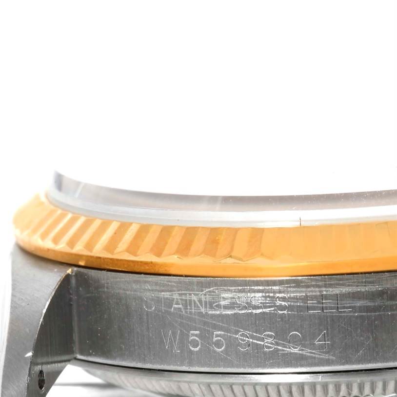 This close-up image of a Rolex Datejust 16233 Men's Steel and Gold (two tone) Blue Dial 16233 Men's Steel and Gold (two tone) Blue Dial watch shows the side view of the bezel and part of the case with the serial number.