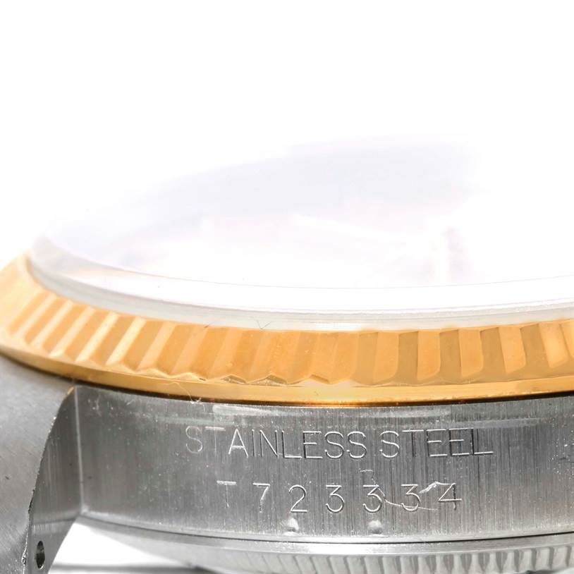 This image shows a close-up of the side of a Rolex Datejust 16233 Men's Steel and Gold (two tone) Champagne Dial 16233 Men's Steel and Gold (two tone) Champagne Dial watch, highlighting the stainless steel case and the gold fluted bezel.