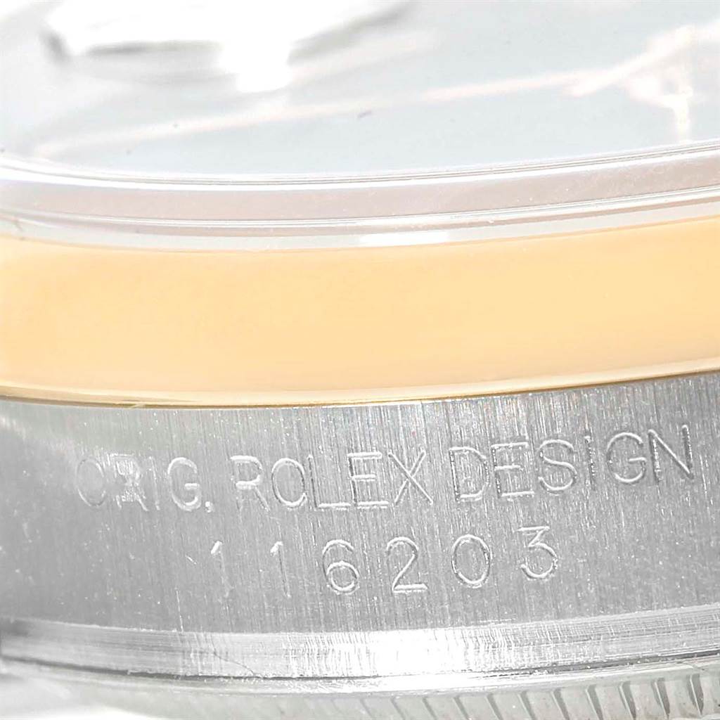 The image shows a close-up of the side of a Rolex Datejust 116203 Men's Stainless Steel Black Dial 116203 Men's Stainless Steel Black Dial watch, highlighting engravings and part of the bezel.