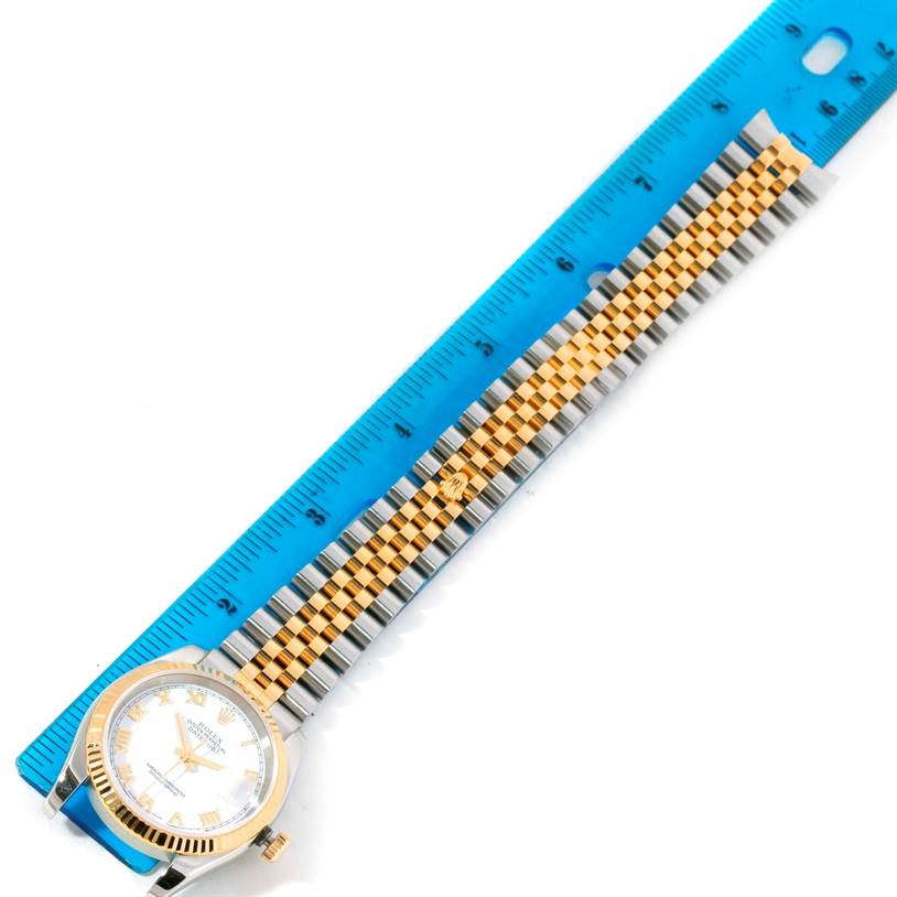 This image shows a Rolex Datejust 116233 Men's Stainless Steel White Dial 116233 Men's Stainless Steel White Dial watch laid flat next to a blue ruler, displaying the face and full band.