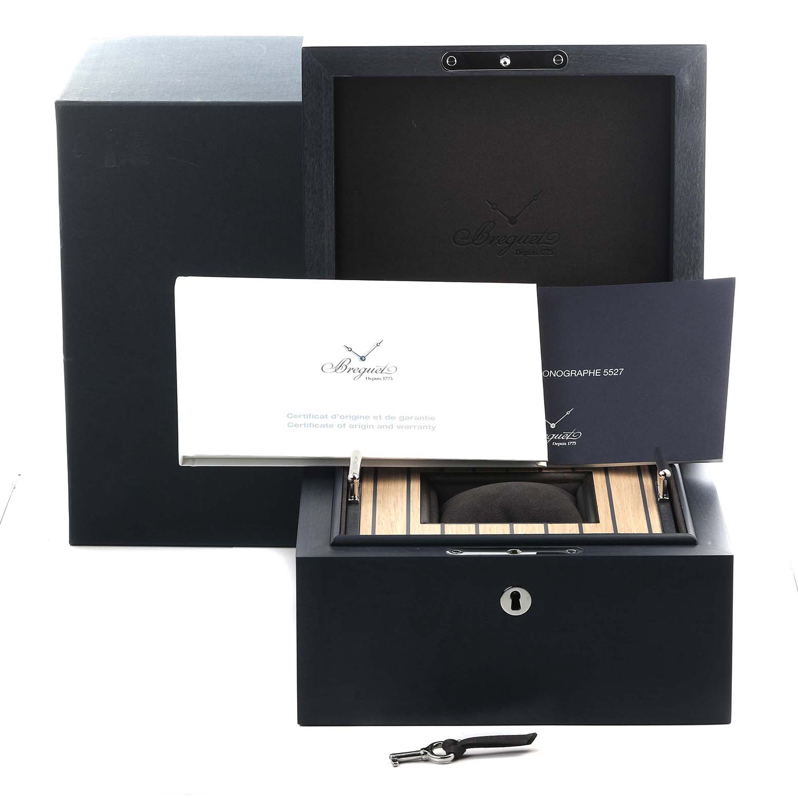 The image shows the Breguet Marine 5527TI/G2/9WV Men's Titanium Grey Dial 5527TI/G2/9WV Men's Titanium Grey Dial model box from the front, with documents and a key placed nearby.