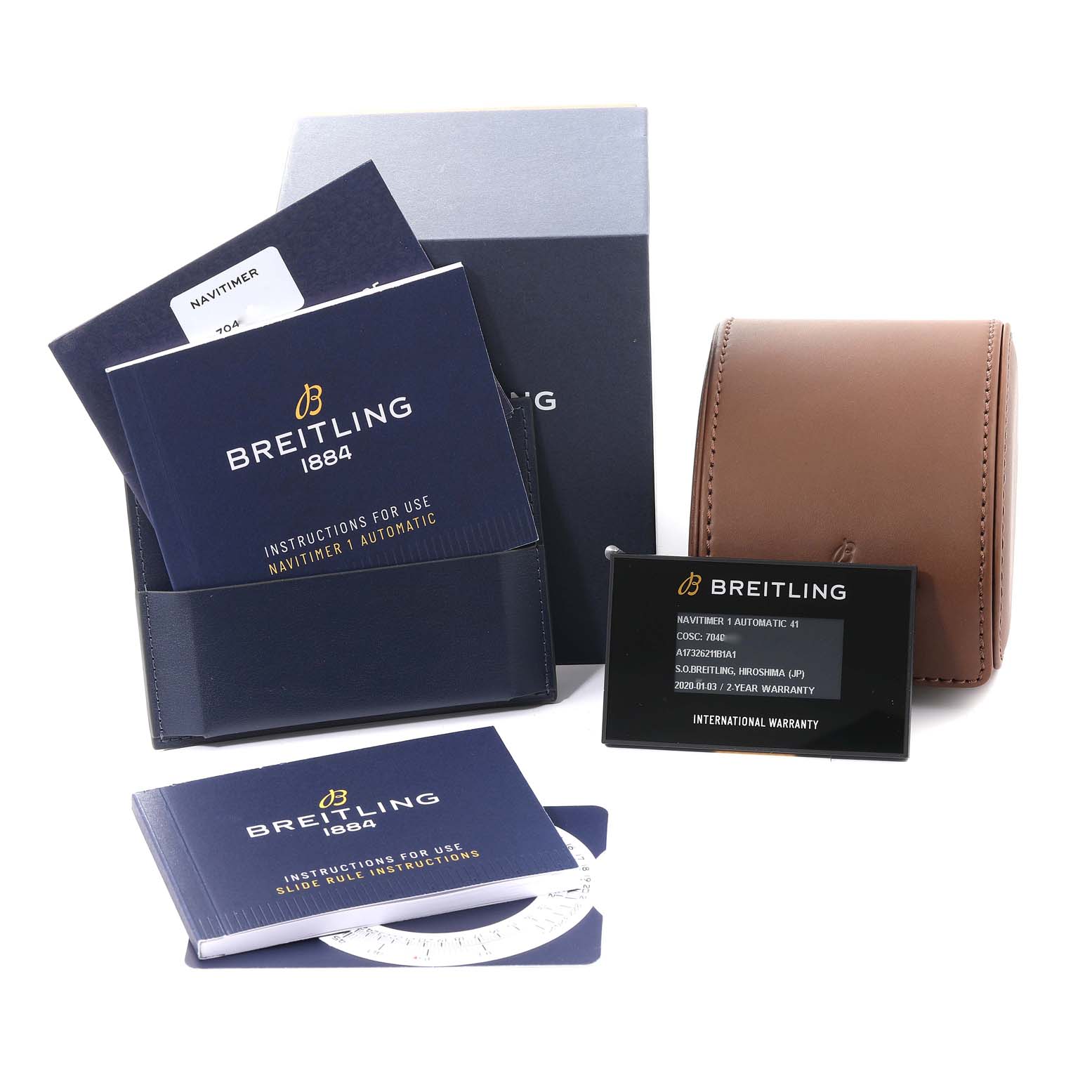 The image shows accessories for the Breitling Navitimer A17326 Men's Stainless Steel Black Dial A17326 Men's Stainless Steel Black Dial watch, including manuals, warranty cards, a box, a leather pouch, and a white scale.