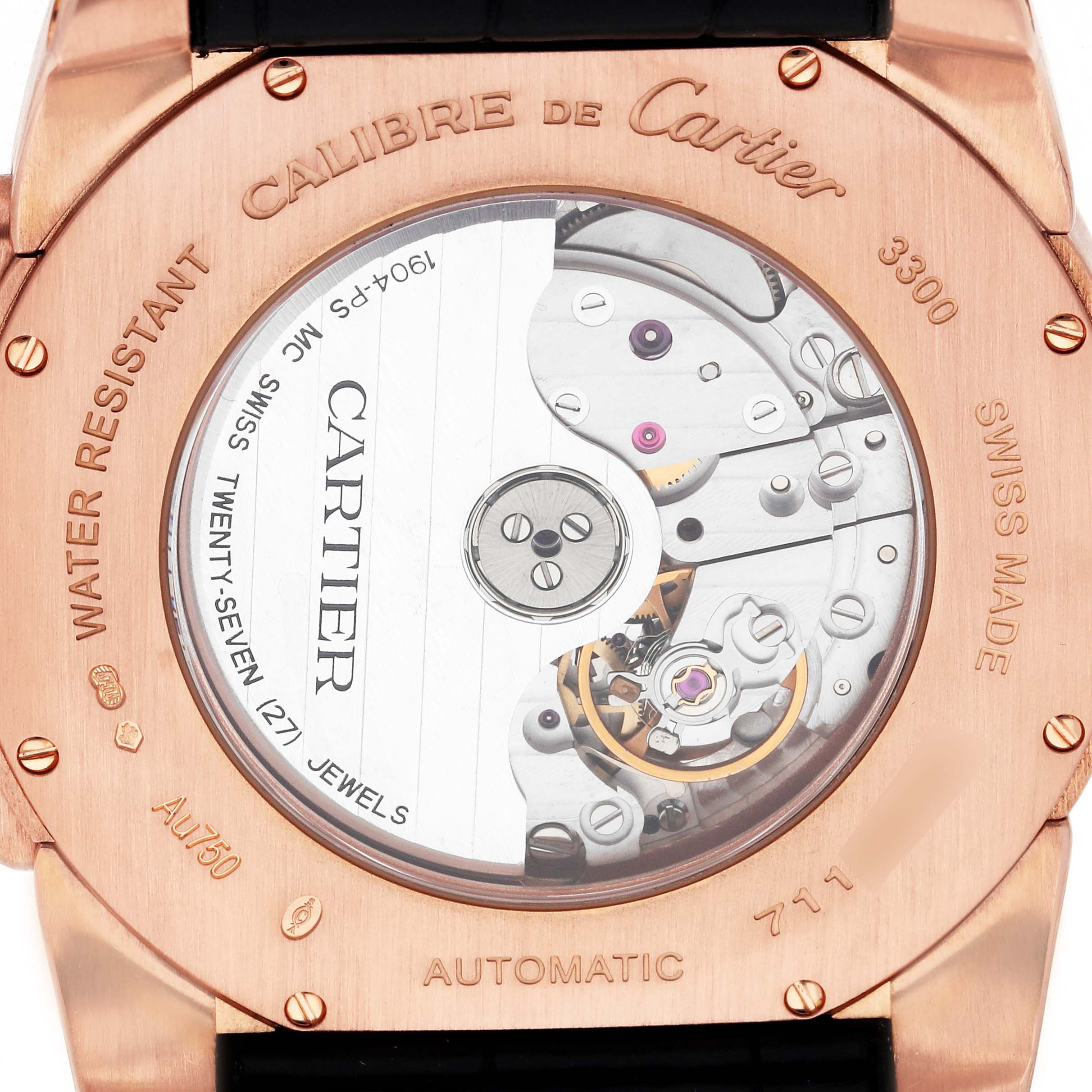 The image shows the back case of the Calibre de Cartier watch, revealing its automatic movement and mechanical components.