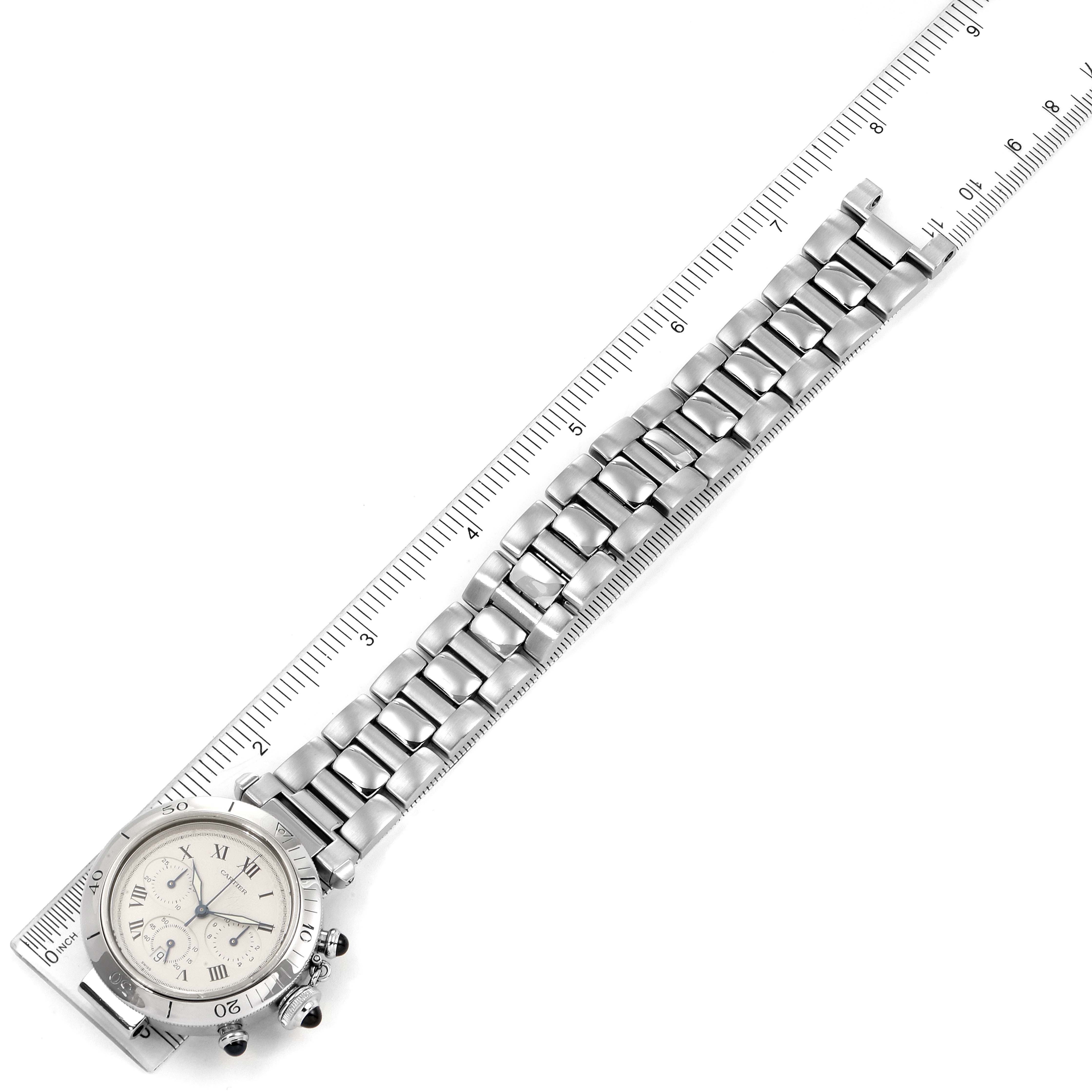 This image shows a Cartier Pasha W31018H3 Men's Stainless Steel Silver Dial W31018H3 Men's Stainless Steel Silver Dial model watch from a top-down angle, highlighting its face and metallic bracelet against a ruler for scale.