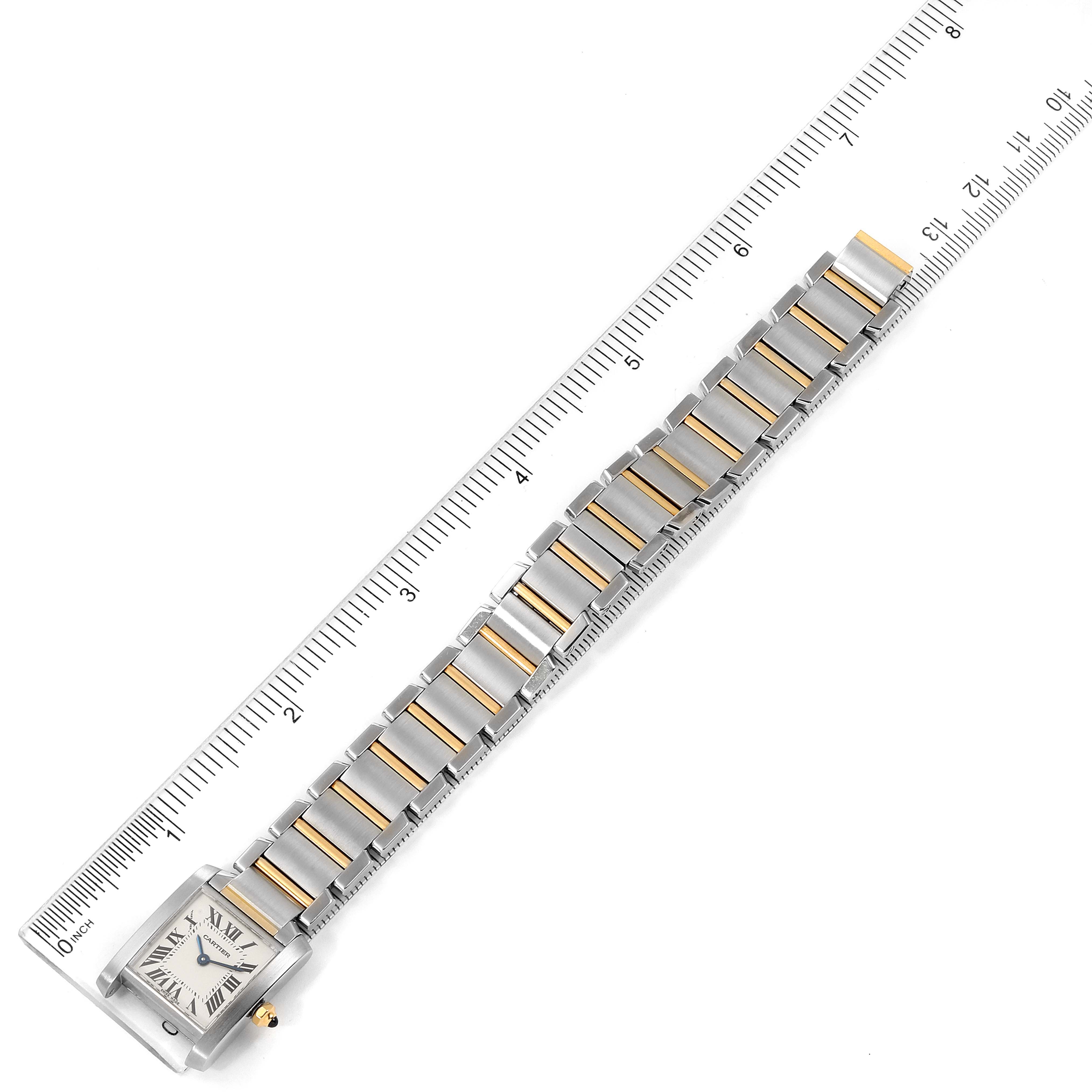 The image shows a top view of a Cartier Tank Française with a ruler measuring its length.