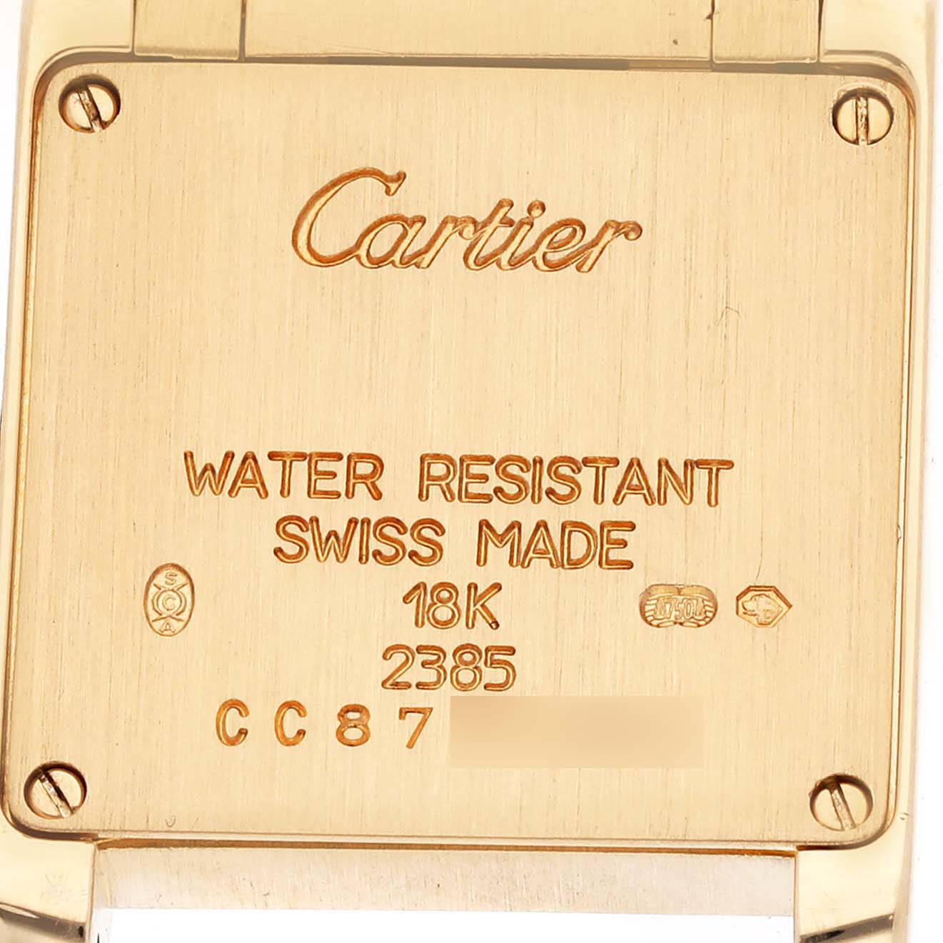 The image shows the back of a Cartier Tank Francaise WE1001R8 Women's Yellow Gold Silver Dial WE1001R8 Women's Yellow Gold Silver Dial watch with inscriptions and markings.