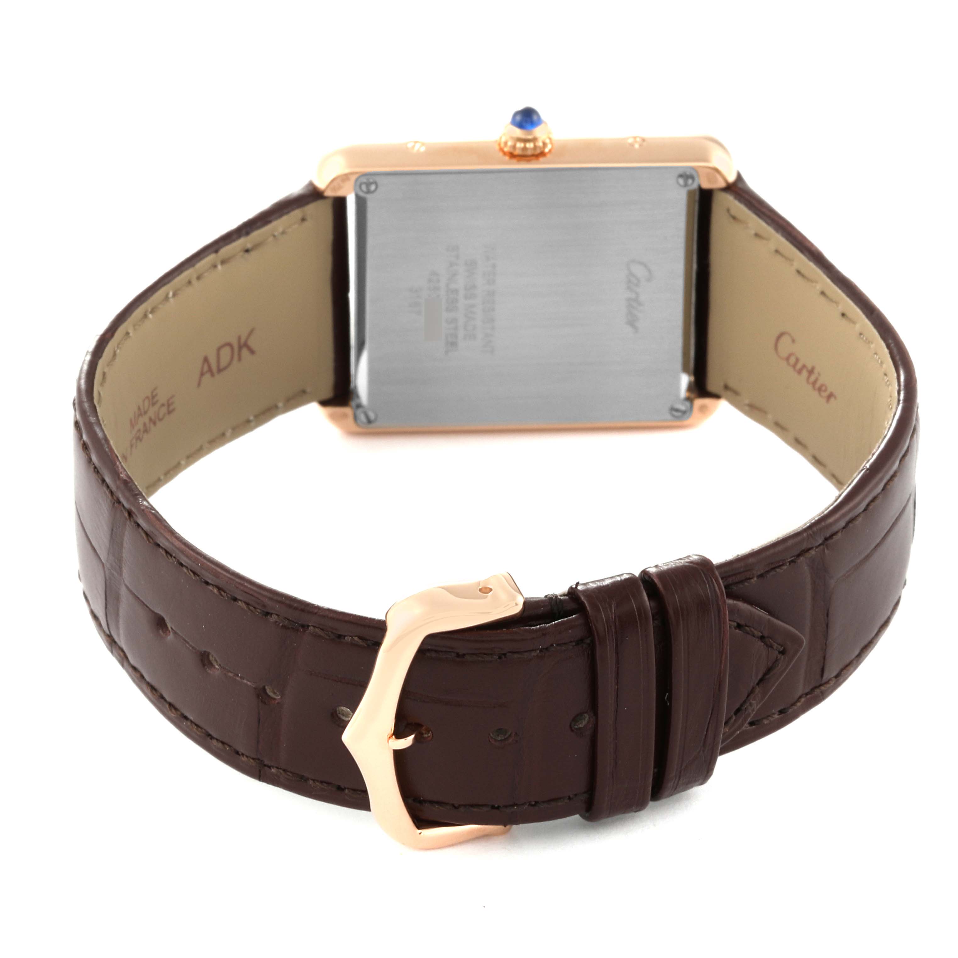 The image shows the back of the Cartier Tank Solo W5200025 Men
s Steel and Gold (two tone) Silver Dial W5200025 Men
s Steel and Gold (two tone) Silver Dial watch, highlighting the case, crown with a blue cabochon, and leather strap with buckle.