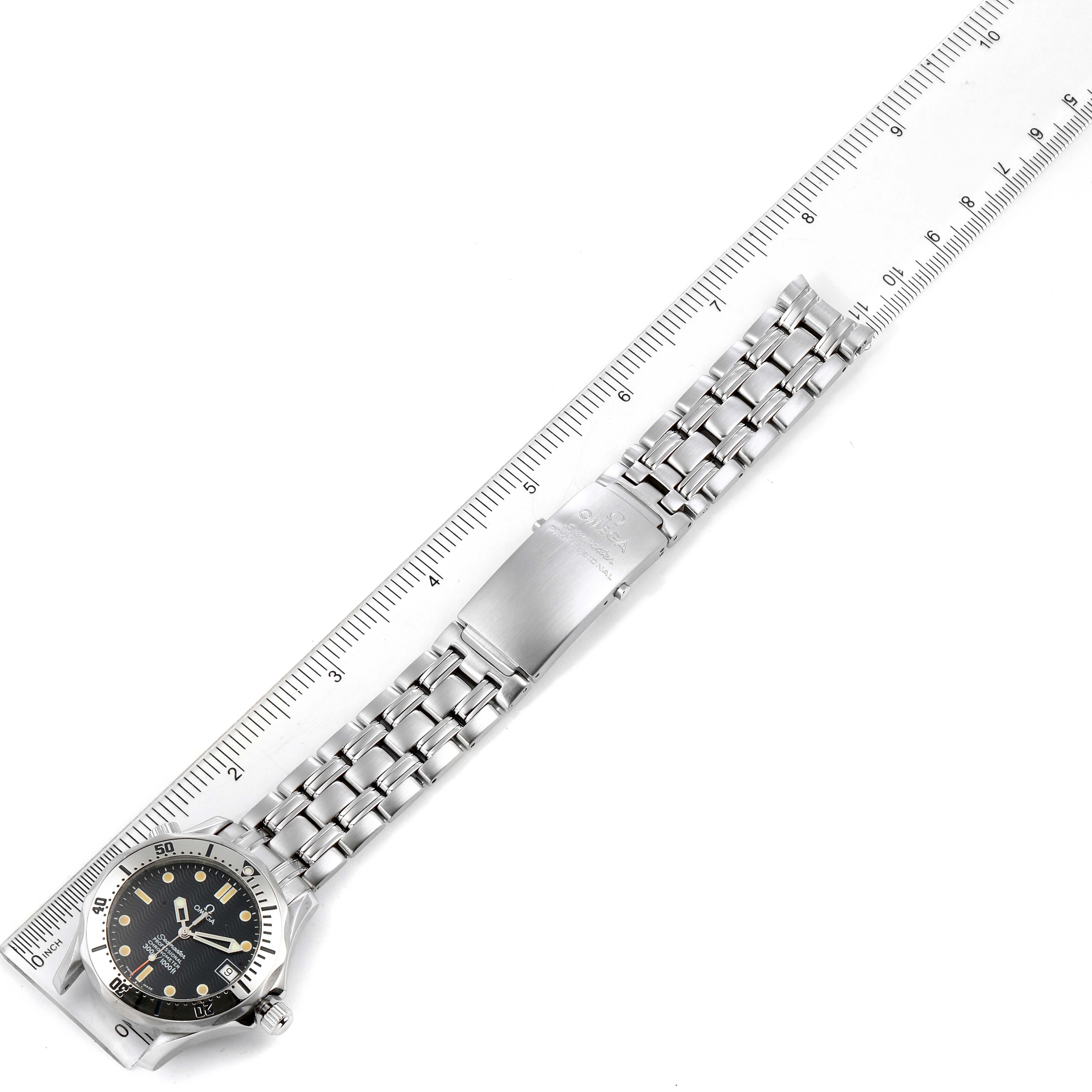 The image shows the top view of an Omega Seamaster 2552.80.00 Men's Stainless Steel Blue Dial 2552.80.00 Men's Stainless Steel Blue Dial watch, highlighting the dial and metal bracelet with clasp, aligned with a ruler.