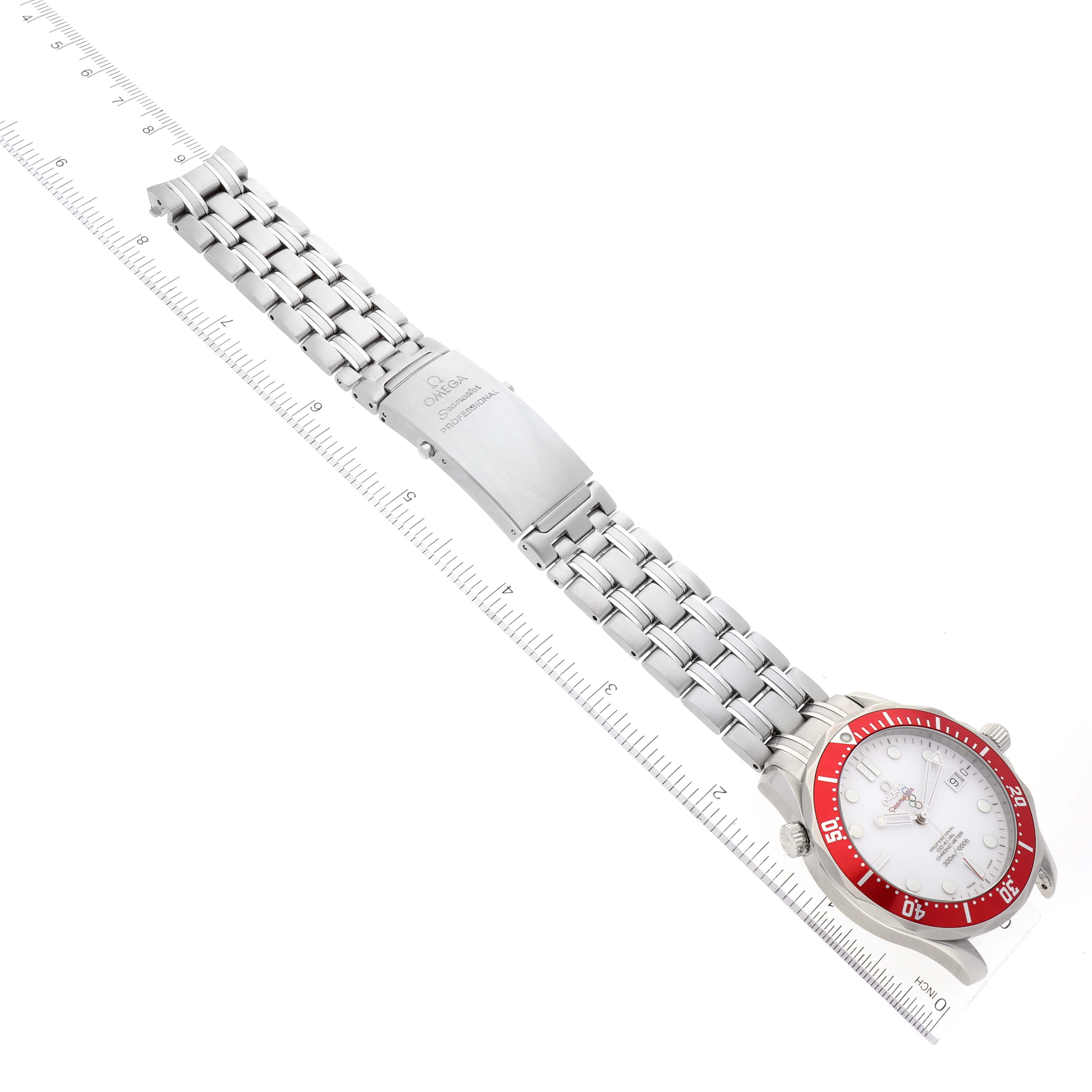 The image shows an Omega Seamaster 212.30.41.20.04.001 Men's Stainless Steel White Dial 212.30.41.20.04.001 Men's Stainless Steel White Dial watch with a metal bracelet and red bezel, laid flat next to a ruler for scale.