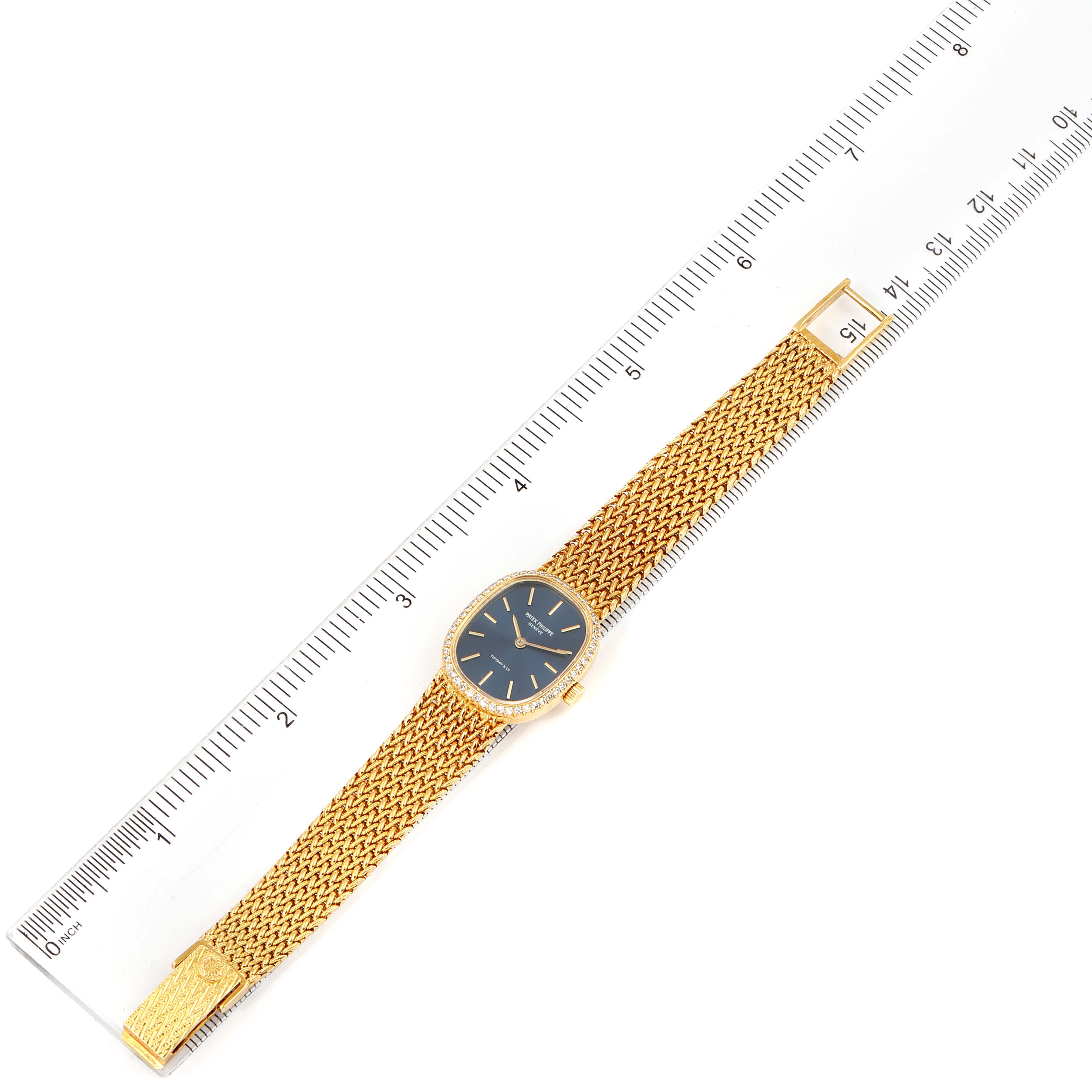 The Patek Philippe Golden Ellipse 4498 Women's Yellow Gold Blue Dial 4498 Women's Yellow Gold Blue Dial watch is shown at a top-down angle, displaying its blue dial, gold case, and woven gold bracelet.