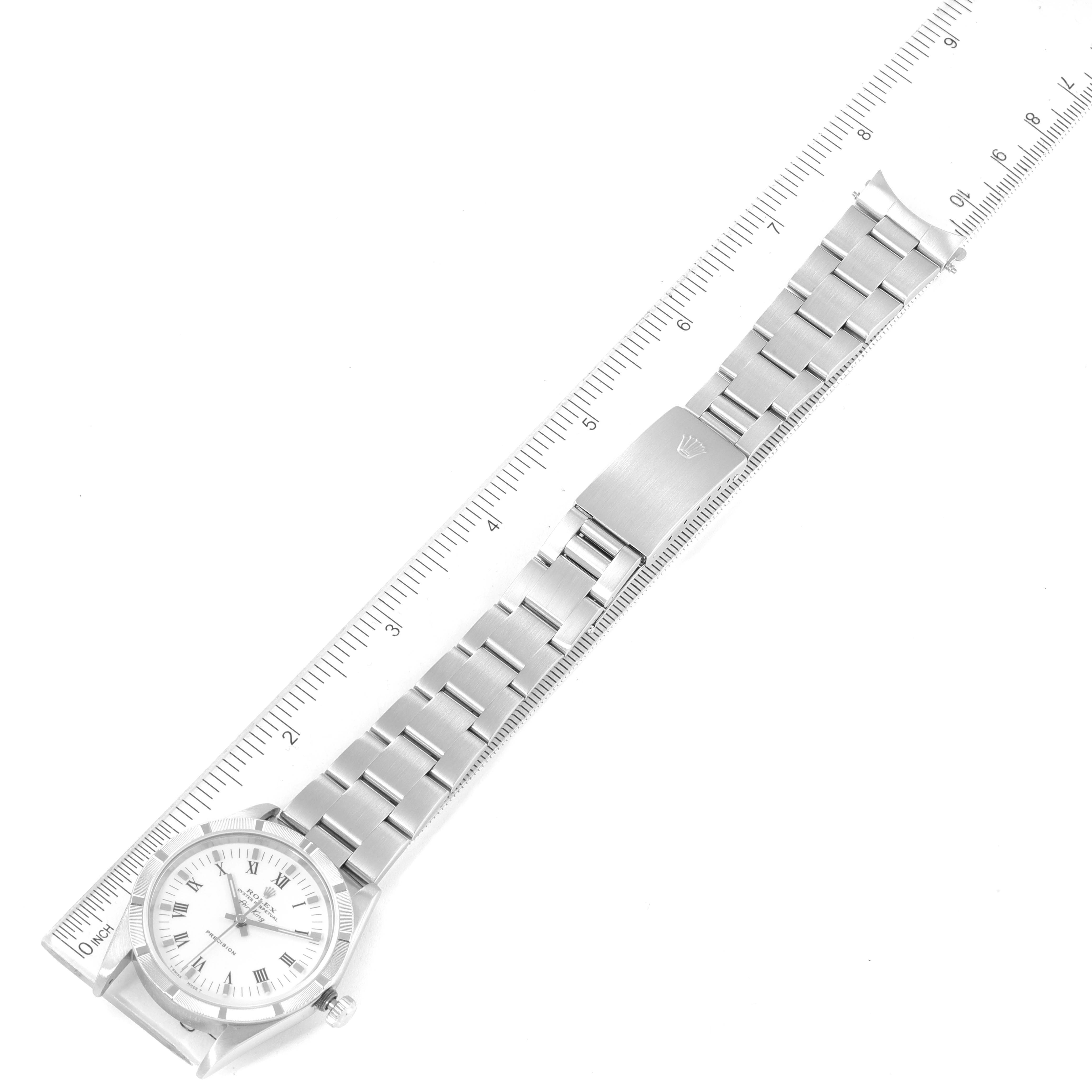 The Rolex Air-King 14010 Men's Stainless Steel White Dial 14010 Men's Stainless Steel White Dial watch is shown from a top-down angle, displaying its face, bracelet, and clasp alongside a measuring ruler.