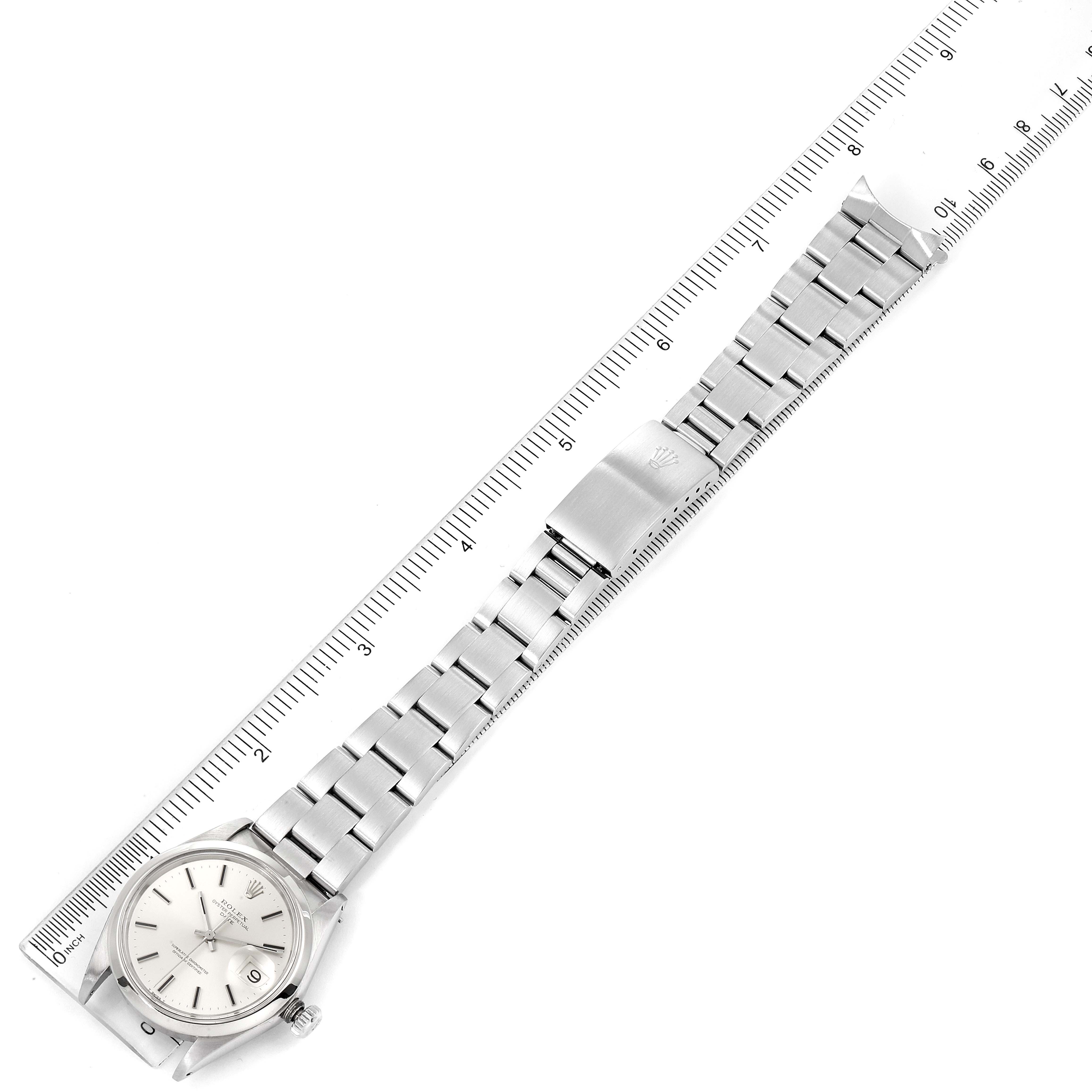 The image shows a top-down view of a Rolex Vintage Collection 1500 Men's Stainless Steel Silver Dial 1500 Men's Stainless Steel Silver Dial watch with a stainless steel bracelet placed along a ruler.