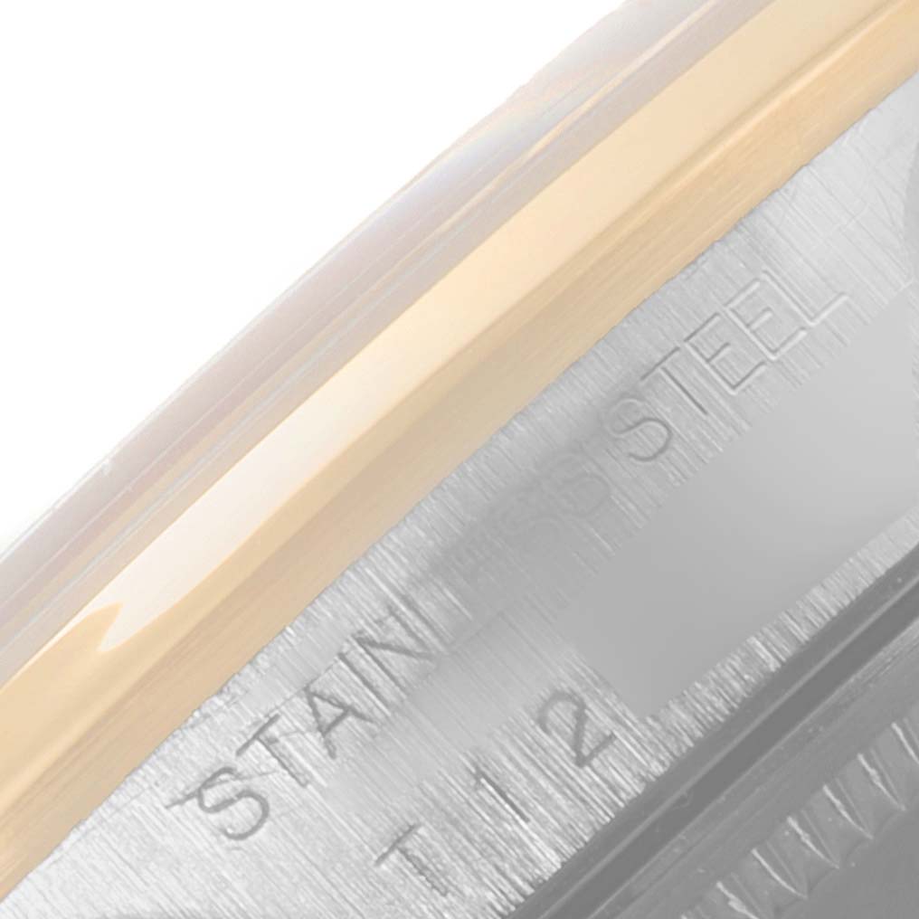 This close-up image shows the bezel and part of the case with engraving on a Rolex Date 15203 Men's Steel and Gold (two tone) Silver Dial 15203 Men's Steel and Gold (two tone) Silver Dial model.