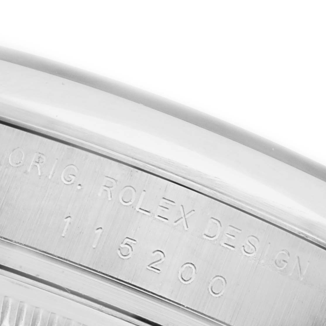 The image shows an angled close-up of the Rolex Date 115200 Men's Stainless Steel White Dial 115200 Men's Stainless Steel White Dial model's engraved case side with the design number.