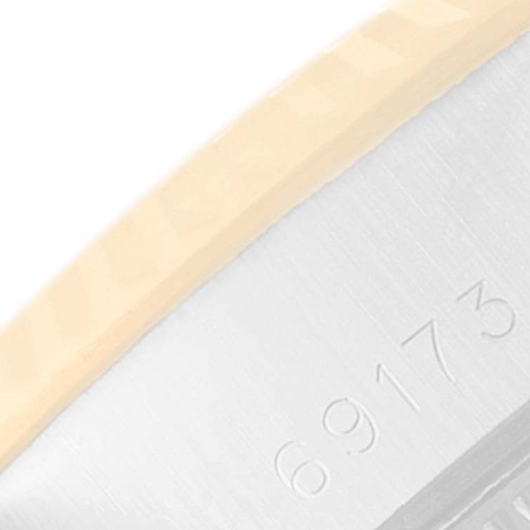 This close-up image shows the side of the Rolex Datejust 69173 Women
s Steel and Gold (two tone) Silver Dial 69173 Women
s Steel and Gold (two tone) Silver Dial model, highlighting its bezel edge and engraved serial number.