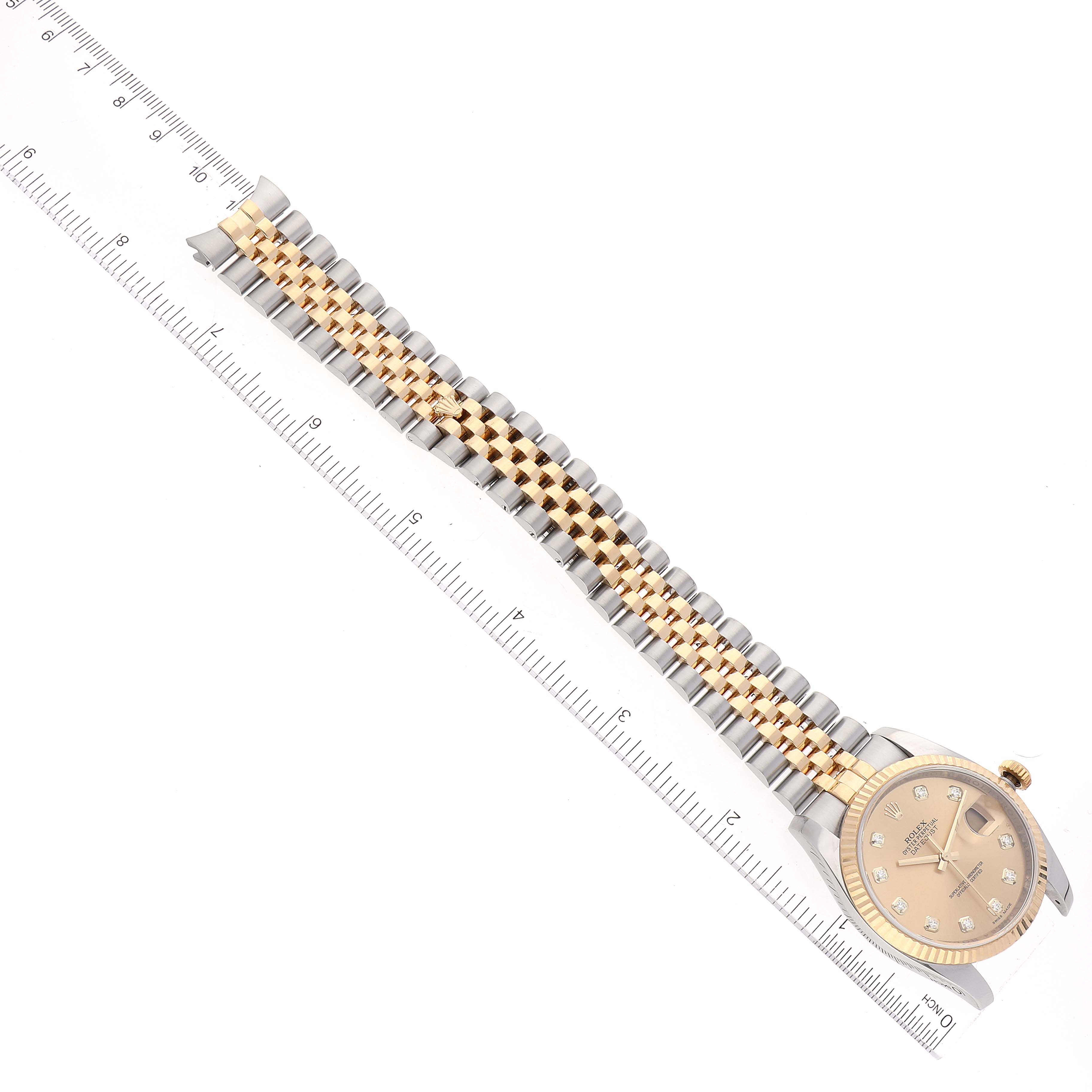 The image shows a Rolex Datejust 116233 Men's Steel and Gold (two tone) Champagne Dial 116233 Men's Steel and Gold (two tone) Champagne Dial model watch with a jubilee bracelet, placed next to a ruler for measurement.