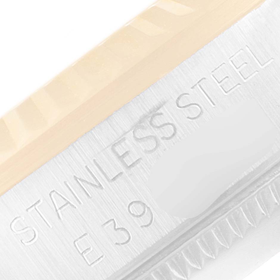 This close-up image of the Mid-Size Rolex watch shows the edge of the bezel and part of the case with "STAINLESS STEEL" engraved.