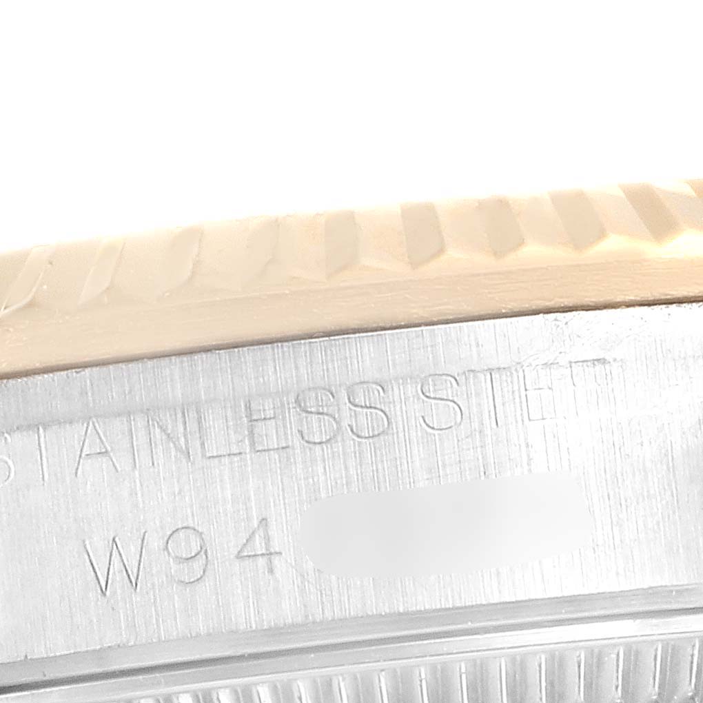 The image shows the side of a Mid-Size Rolex watch, focusing on the edge of the bezel and the stainless steel case with engravings.