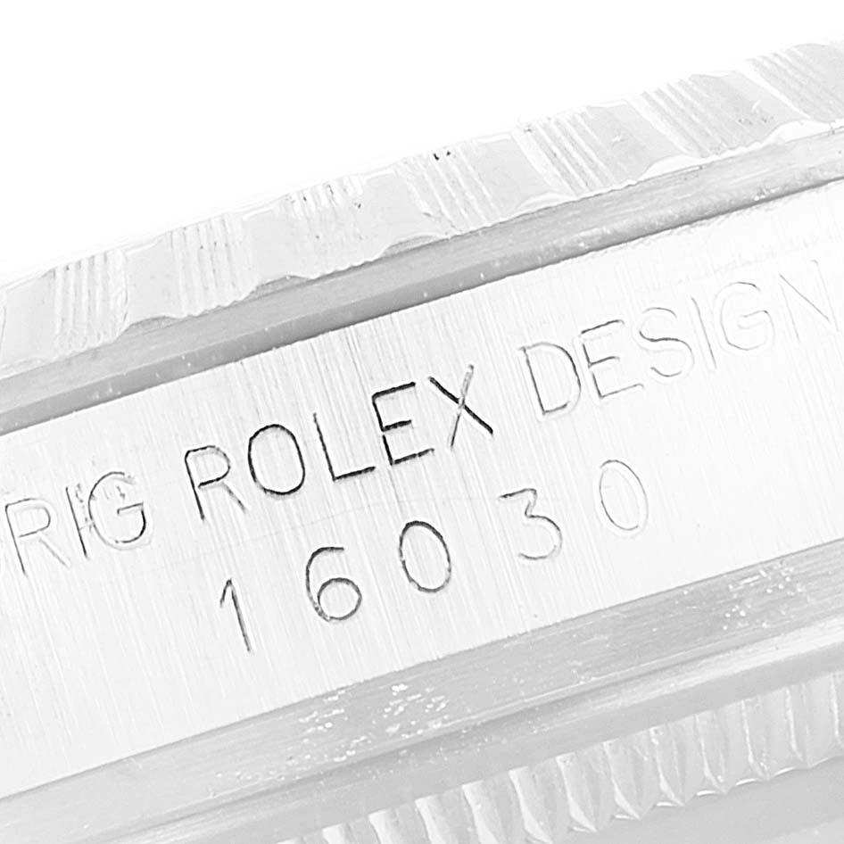 This close-up image shows the engraved serial number and part of the bezel of the Rolex Vintage Collection 16030 Men's Stainless Steel Silver Dial 16030 Men's Stainless Steel Silver Dial model.