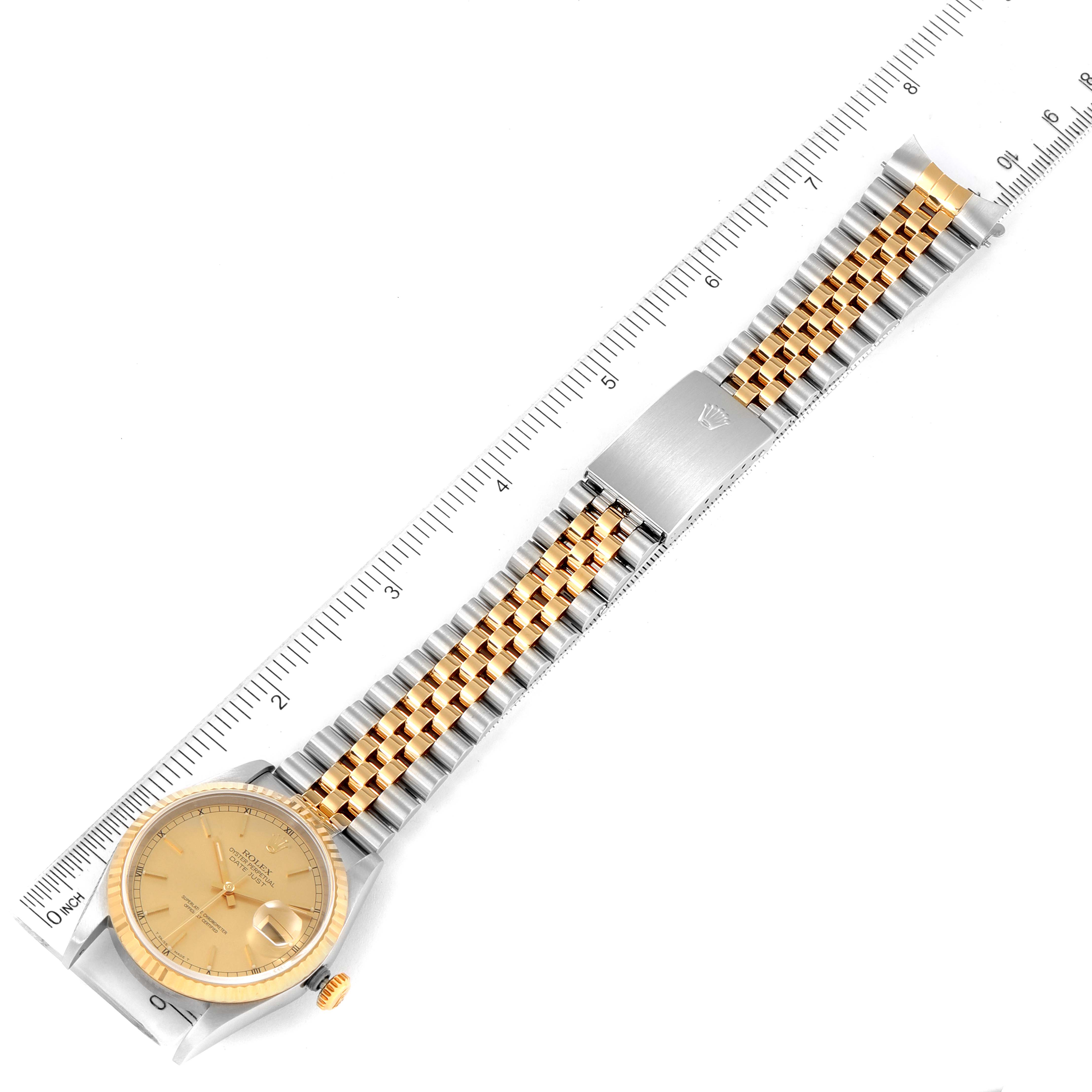 The image shows a top-down view of a Rolex Datejust 16233 Men
s Steel and Gold (two tone) Champagne Dial 16233 Men
s Steel and Gold (two tone) Champagne Dial watch with its full bracelet and a ruler for scale.
