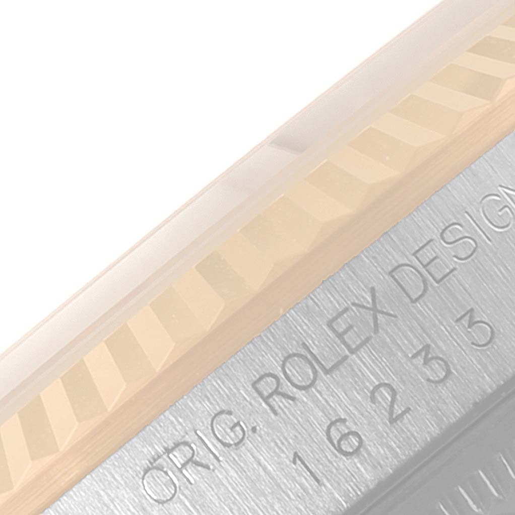 The image shows a close-up of the fluted bezel and a part of the casing with the engraving on a Rolex Datejust 16233 Men
s Steel and Gold (two tone) Champagne Dial 16233 Men
s Steel and Gold (two tone) Champagne Dial watch.