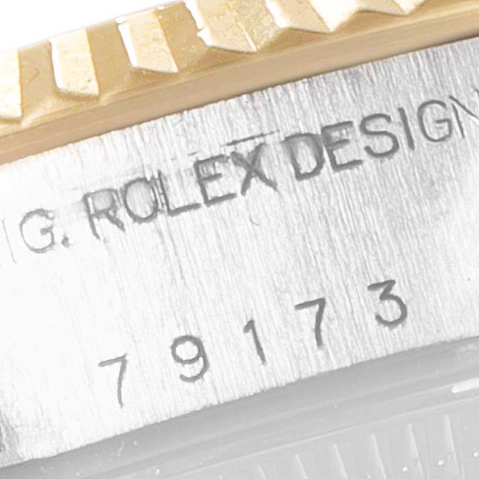 This image shows a close-up of the fluted bezel and engraved serial number on a Rolex Datejust 79173 Women
s Steel and Gold (two tone) Champagne Dial 79173 Women
s Steel and Gold (two tone) Champagne Dial.