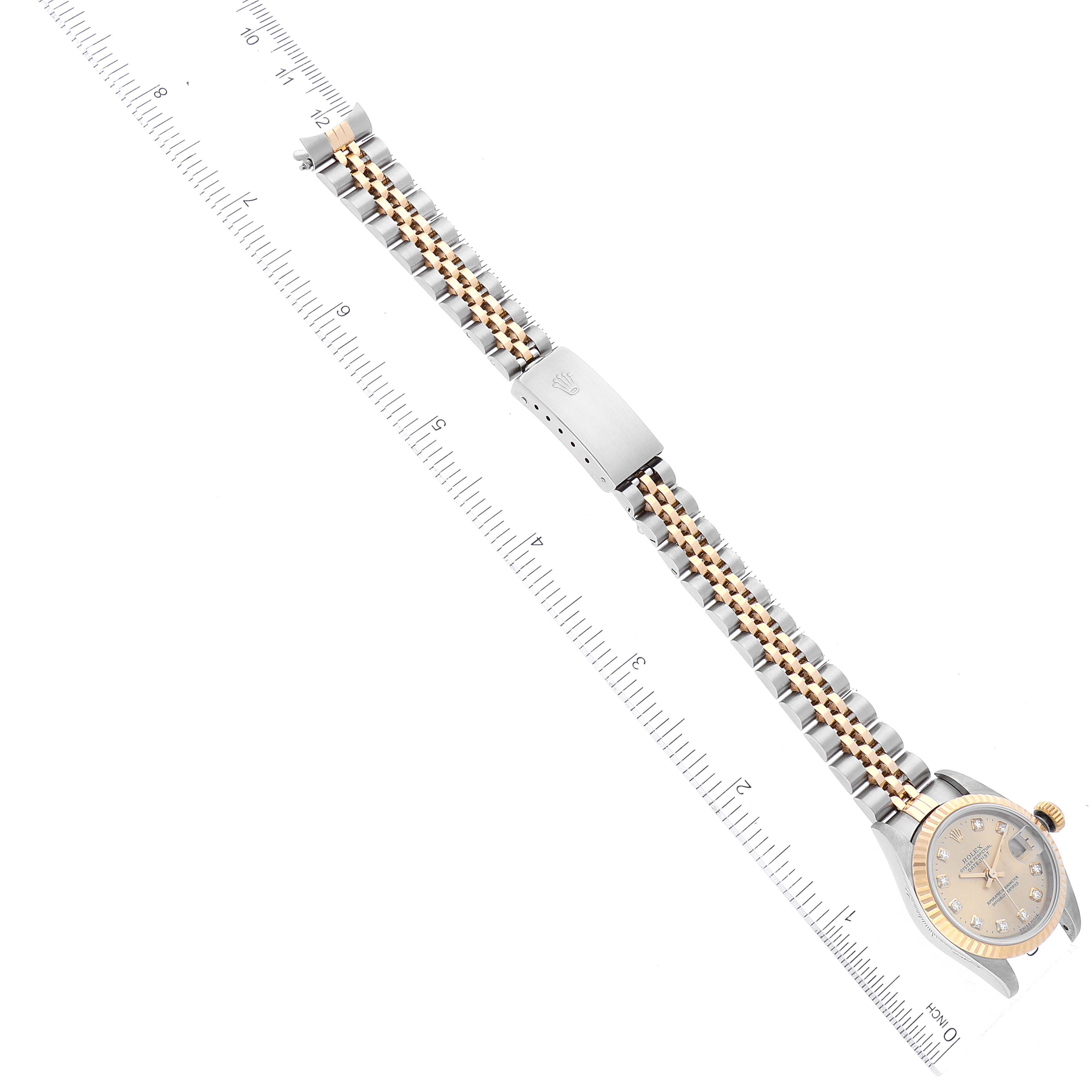 The image shows a Rolex Datejust 79173 Women's Steel and Gold (two tone) Champagne Dial 79173 Women's Steel and Gold (two tone) Champagne Dial watch laid flat with a ruler, displaying its face and bracelet clearly.