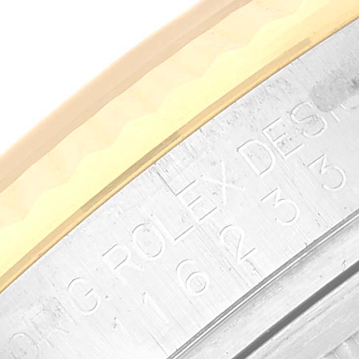 This image shows a close-up of the bezel and engraved part of the case side of a Rolex Datejust 116233 Men's Steel and Gold (two tone) Champagne Dial 116233 Men's Steel and Gold (two tone) Champagne Dial watch.