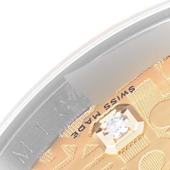This image shows a close-up of the dial and bezel of a Rolex Datejust 116233 Men's Steel and Gold (two tone) Champagne Dial 116233 Men's Steel and Gold (two tone) Champagne Dial watch, highlighting a diamond marker and part of the "Swiss Made" text.