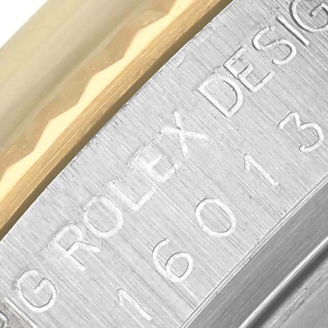 The image shows a close-up of the Rolex Datejust 16013 Men's Steel and Gold (two tone) Champagne Dial 16013 Men's Steel and Gold (two tone) Champagne Dial model's metal case and part of the bezel, highlighting engraved text.