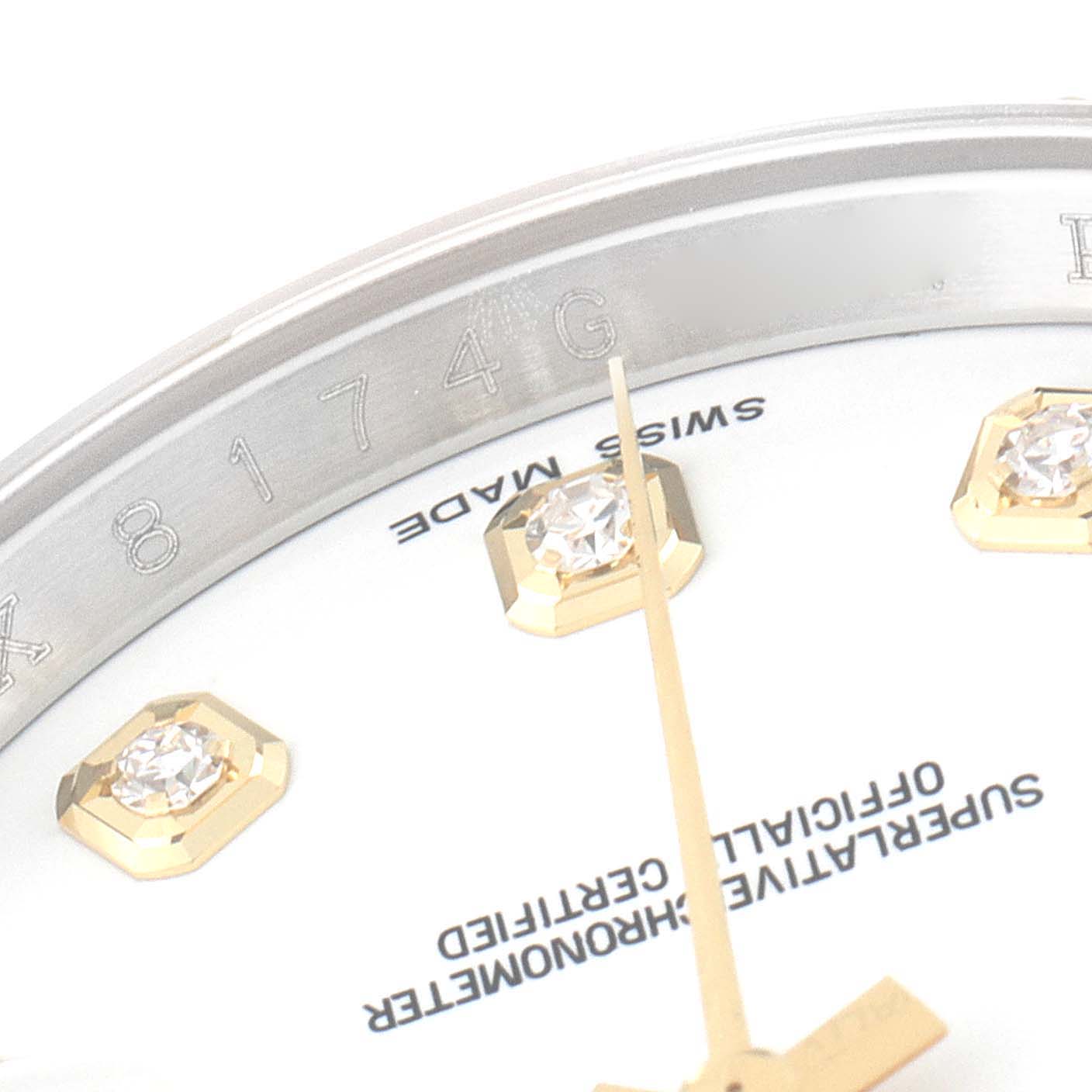 This close-up image of a Rolex Datejust 116233 Men's Steel and Gold (two tone) White Dial 116233 Men's Steel and Gold (two tone) White Dial watch shows part of the bezel, dial, diamonds, and minute hand.