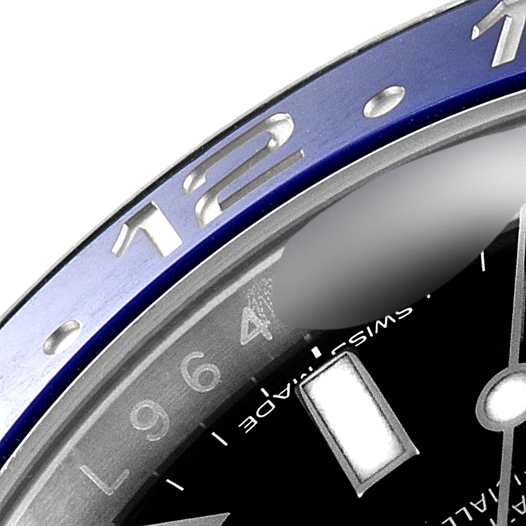 This image shows a close-up of the bezel and part of the face of a Rolex GMT-Master 116710 Men
s Stainless Steel Black Dial 116710 Men
s Stainless Steel Black Dial watch, focusing on the 12 o
clock marker.