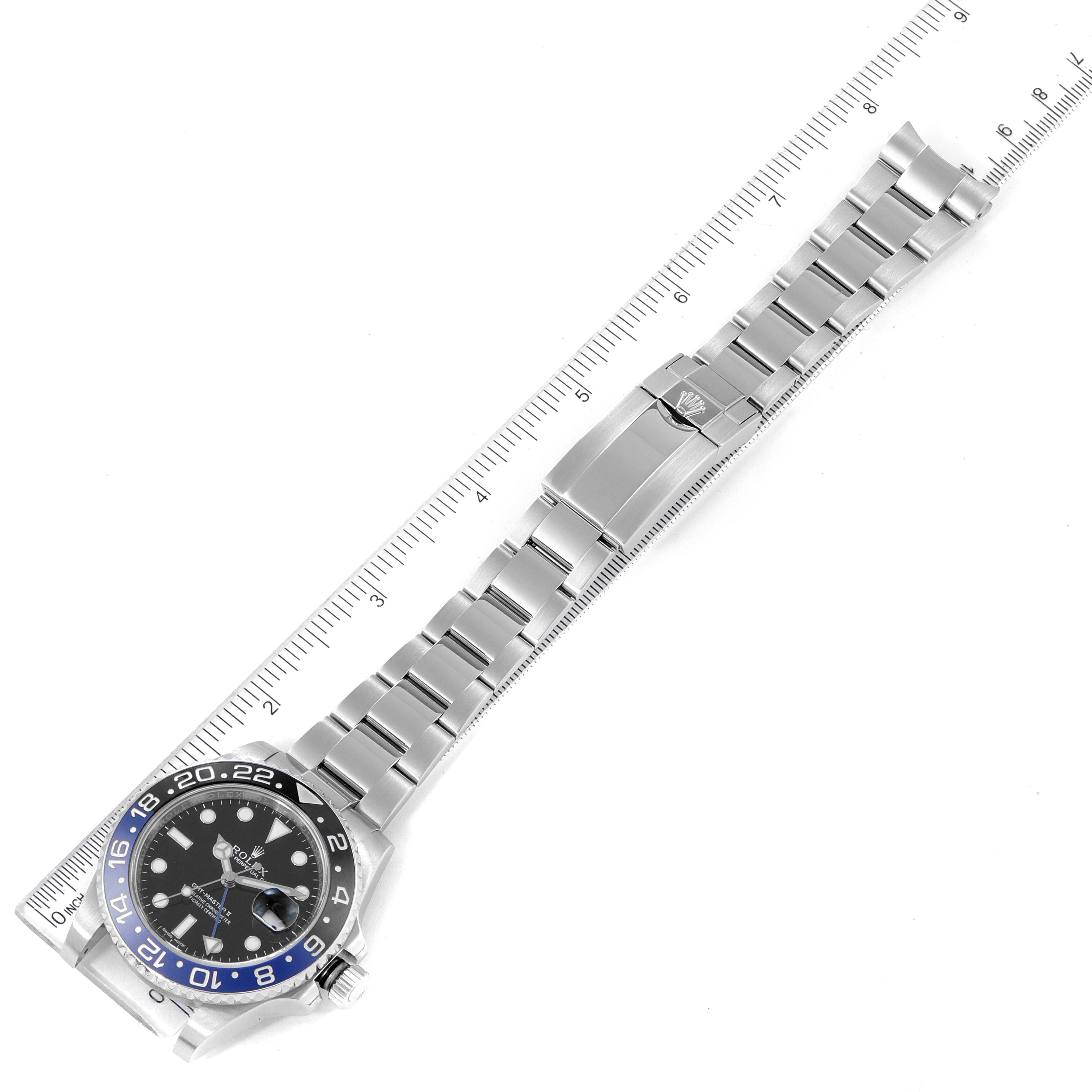 The image shows a top-down view of a Rolex GMT-Master 116710 Men
s Stainless Steel Black Dial 116710 Men
s Stainless Steel Black Dial watch with its bracelet extended alongside a ruler.