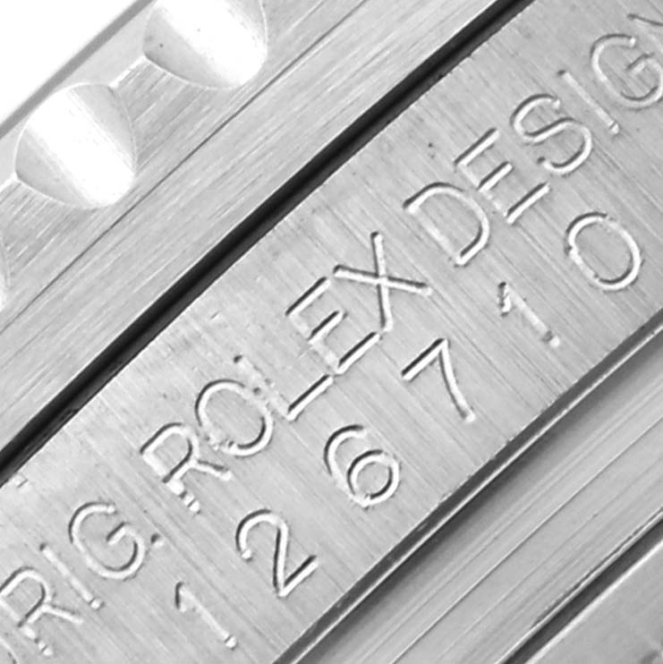 The image shows a close-up of the Rolex GMT-Master 126710BLNR Men's Stainless Steel Black Dial 126710BLNR Men's Stainless Steel Black Dial's bezel edge and the engraved inner ring.