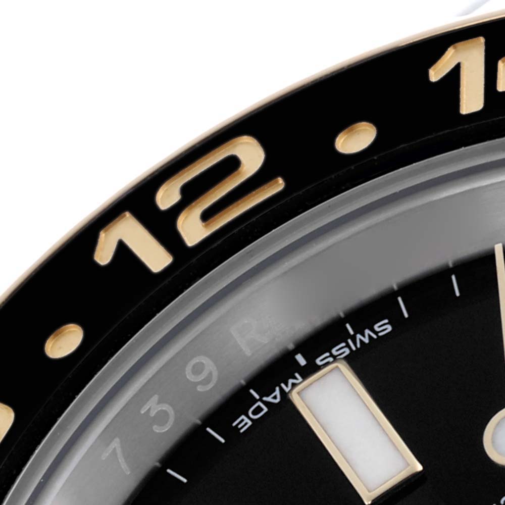 The image shows a close-up of the bezel and part of the dial on a Rolex GMT-Master 116713LN Men's Steel and Gold (two tone) Black Dial 116713LN Men's Steel and Gold (two tone) Black Dial, highlighting the "12" marker.