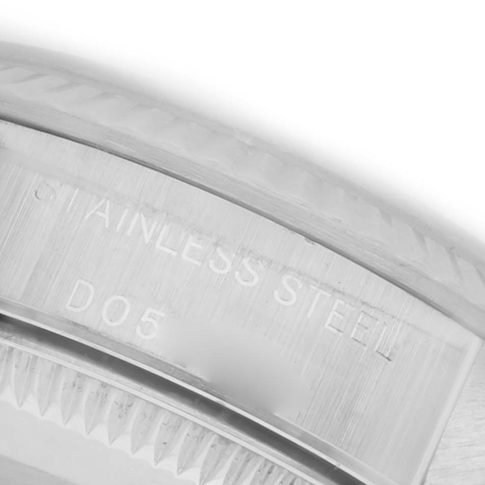 The image shows a close-up of the stainless steel casing and serrated bezel of a Rolex Oyster Perpetual 76094 Women's Stainless Steel Black Dial 76094 Women's Stainless Steel Black Dial.