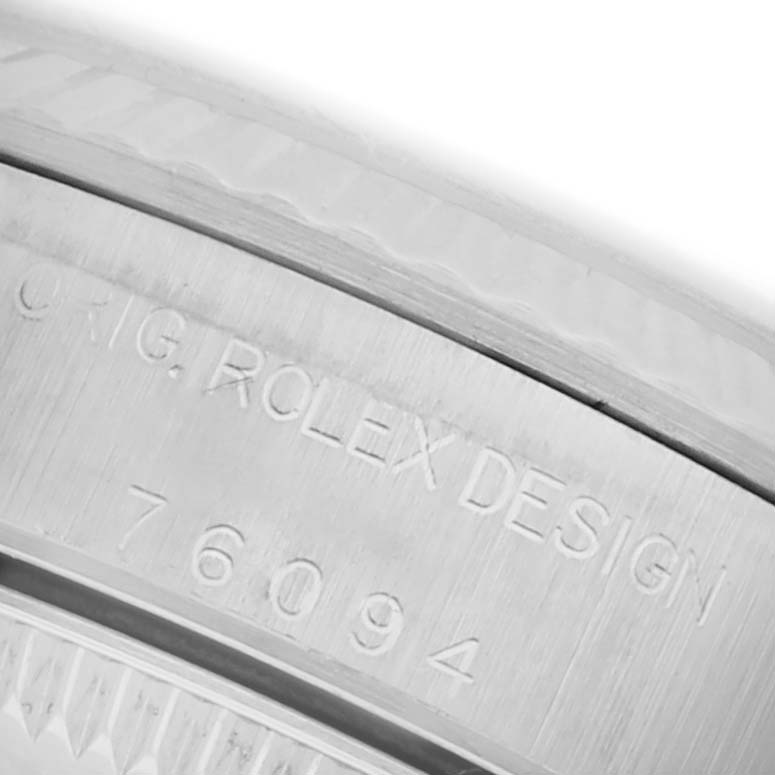 The image shows a close-up of the Rolex Oyster Perpetual 76094 Women's Stainless Steel Black Dial 76094 Women's Stainless Steel Black Dial watch case edge, highlighting the engraved model number.