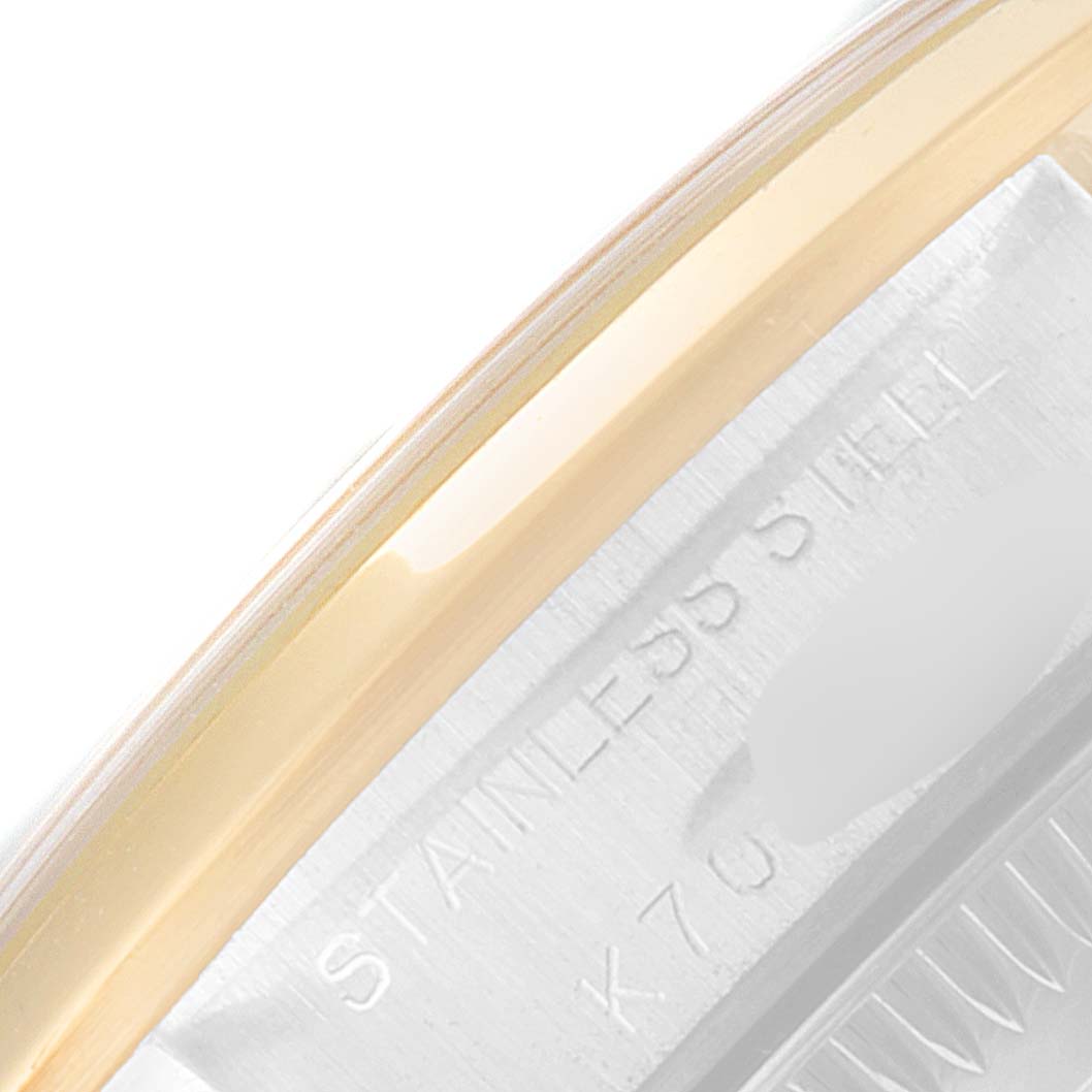 This image shows a close-up of the side of the casing and part of the bezel of a Rolex Oyster Perpetual 76183 Women's Steel and Gold (two tone) Grey Dial 76183 Women's Steel and Gold (two tone) Grey Dial watch, highlighting the "STAINLESS STEEL" engraving.